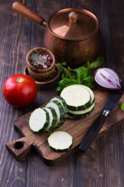 Kabak dilimleri ve ahşap bir masa üzerine soğan ile.