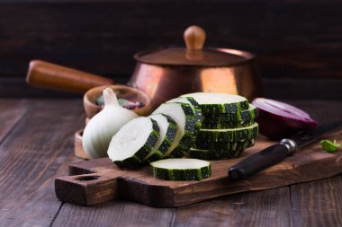 Kabak dilimleri ve ahşap bir masa üzerine soğan ile.