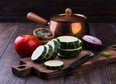 Kabak dilimleri ve ahşap bir masa üzerine soğan ile.