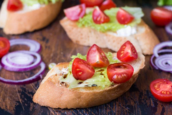 Bruschetta domates, otlar ve kızarmış sarımsaklı ekmek üzeri yağlıboya — Stok fotoğraf