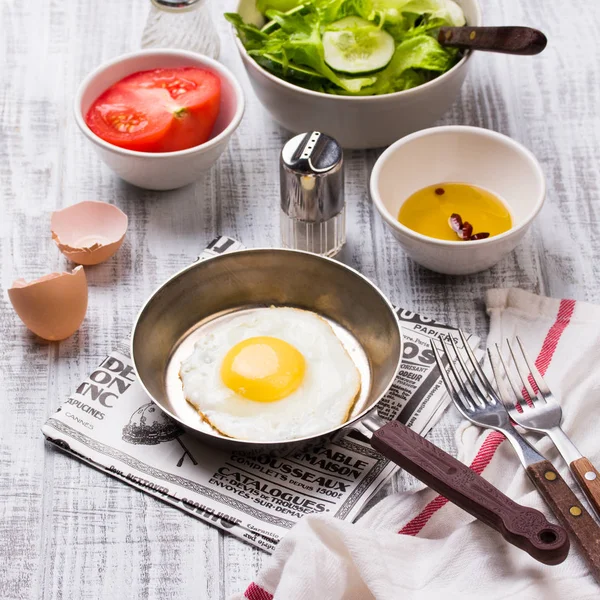 Huevos fritos en una sartén con tomates y ensalada de verduras para el desayuno —  Fotos de Stock
