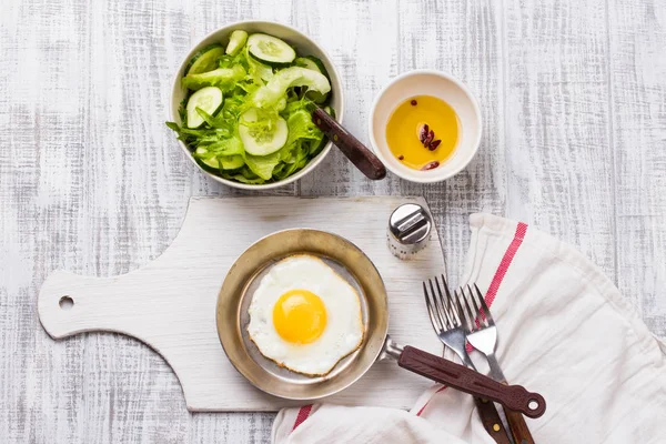 Fried eggs in a frying pan with tomatoes and vegetable salad for breakfast — Stock Photo, Image