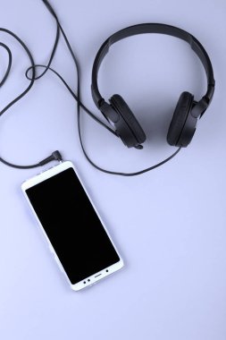 cep telefonu ve kulaklık eski bir ahşap masa üzerinde yatıyordu