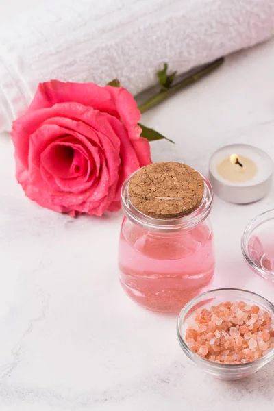 Tratamento de SPA definido com sal marinho, óleo de aroma de rosa e rolo de toalha — Fotografia de Stock