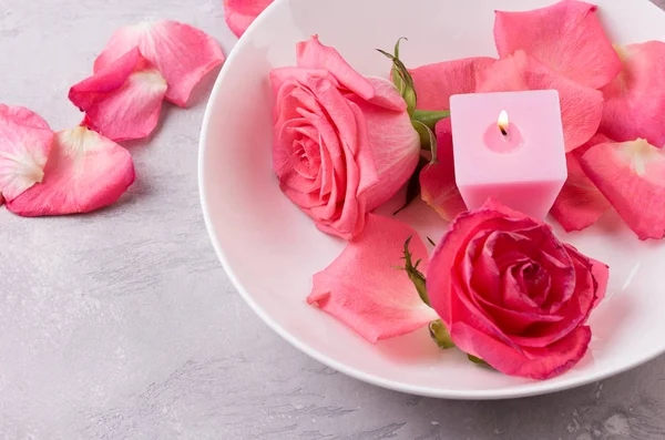 Roze bloemblaadjes van rozen en brandende kaarsen — Stockfoto