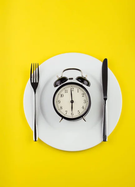 Weight loss or diet concept. stock image of alarm clock on plate — 스톡 사진