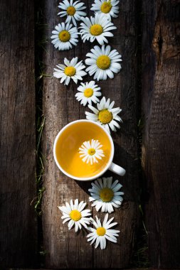 Papatya çiçekli bir fincan bitki çayı.