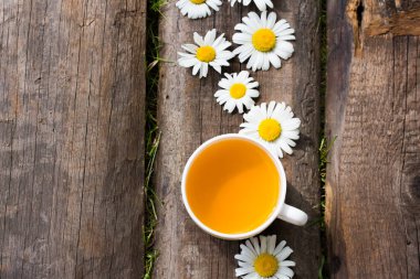 Papatya çiçekli bir fincan bitki çayı.