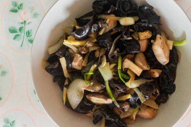 Kai pad kralı. Mantar, tavuk, soğan, taze soğan ve zencefil ile hazırlanmış Tayland yemeği, beyaz bir tabakta servis edilir.