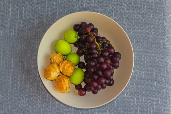 Fruits on a plate. Red grapes, jujubes and gooseberries.