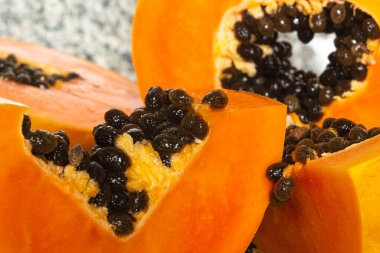 Yeşil bir kesme tahtasında kesilmiş lezzetli turuncu papaya meyvesi.