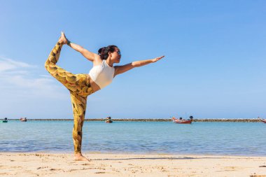 Taylandlı kadın Haad Chaloklum plajında yoga yapıyor, Koh Phangan adası, Tayland. Dansın efendisi pozu.