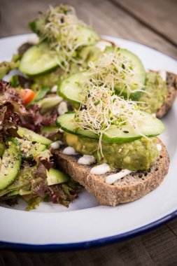  Avokado ve salatalıklı sandviç bir parça Ray ekmeği, yan görüş