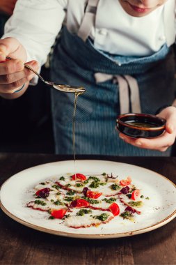 Şef Ahtapot Carpaccio 'yu hazırlıyor, tabağa sos döküyor, mutfak işi yapıyor.. 