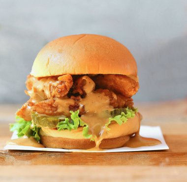 Masada kızarmış tavuk burgeri, gurme kreasyonları, yan görüş. Çıtır tavuklu burgeri kapat.. 