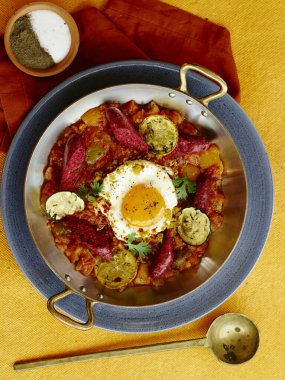 Kızarmış yumurta, yumurtalı yumurta, fırında sebze, fırında domates, tavada pita ekmeği ve Shakshuka kaşığıyla bir masanın üstünde patlıcan. Domatesli yumurta ve kızartma tavasında kızarmış ekmek.. 