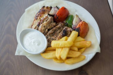 Kızarmış tavuk, patates kızartması ve sebze. Rosto, restoran..