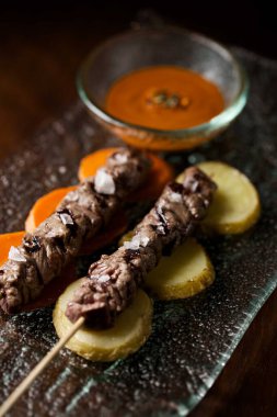 Kebap, şiş kebap, sopa üzerinde bbq et, masada salsa sosu, üst manzara. Lezzetli et ve sebze kebabı..