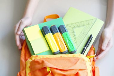 Okul malzemeleriyle dolu turuncu sırt çantası. Okula Dönüş