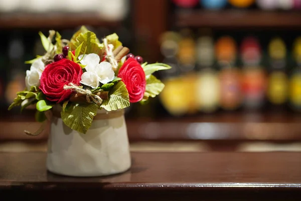 Strauß weißer und roter Blumen in einer hellen Keramikvase auf der Tischplatte — Stockfoto