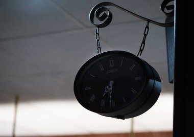 Modern bar barının içinde siyah saatler zincirli.