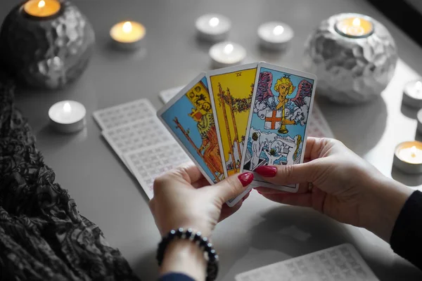 Tarot olvasó szedés tarot kártyák, közel égő gyertyák. — Stock Fotó