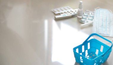 Tıbbi malzemelerin olduğu mavi bir market sepeti..