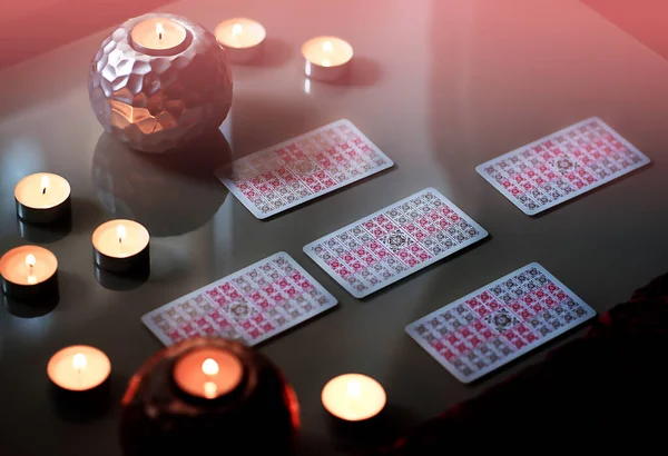 Lector de tarot recogiendo cartas del tarot cerca de velas encendidas . — Foto de Stock