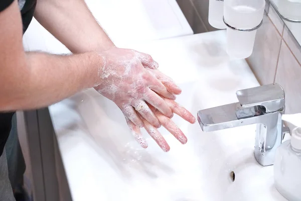 Man wassen zijn handen met zeep thuis. — Stockfoto