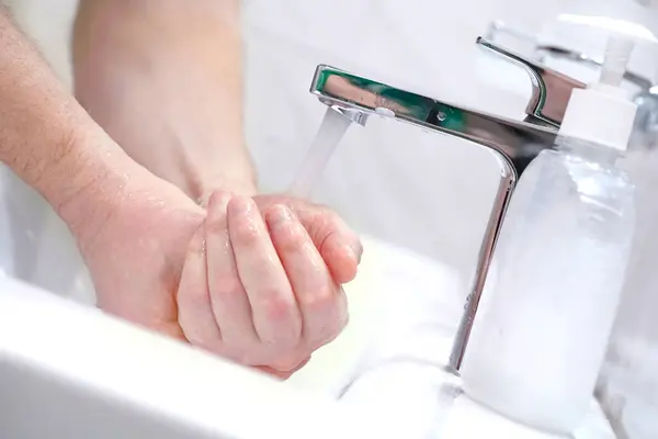 Homme se laver les mains avec du savon à la maison . — Photo