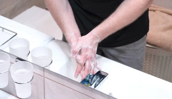 男は家で石鹸で手を洗う. — ストック写真