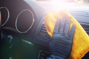 Arabanın içini koronovirüs ve dezenfektan sıvısıyla temizliyorum. Elleri lastik koruyucu eldivenlerde. Viral hastalıklara karşı korumak için arabayı temizleyin.