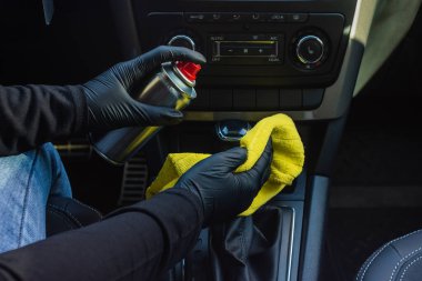 Bir arabanın iklim sistemini ve klimasını koronovirüsten temizlemek ve dezenfektan sıvısı olan bir salgın. Elleri lastik koruyucu eldivenlerle silin.