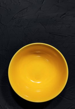 Çatı katında ya da grunge tarzında el yapımı siyah arka planda sarı seramik plaka. Bir kafe ya da lokanta yaratmak, tepeden görünüm