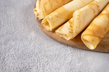 Tahtadaki altın krepler. Kahvaltı vakti geldi. Gri arka planda krep servisi. 