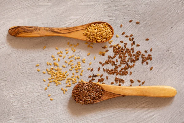 Superfood, diet food. Mix seeds of white and brown flax on a gray background.