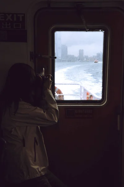 HONG KONG, CHINA - 22 DE NOVIEMBRE DE 2016: Personas en un ferry. Los rascacielos de Hong Kong en el fondo mientras navega en ferry . — Foto de Stock