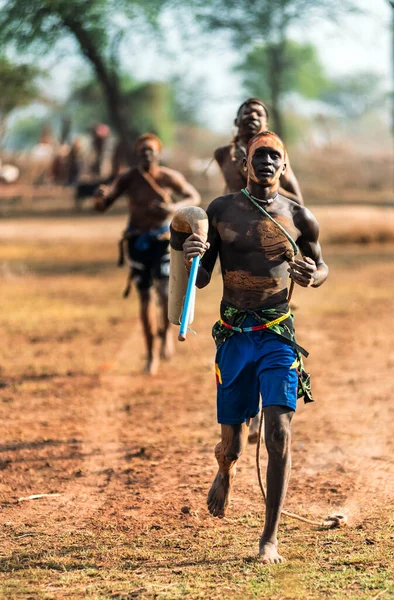 MUNDARI TRIBE, SOUTH SUDAN - MARCH 11, 2020: Young men with painted faces running together during training in savanna near Mundari Tribe village in South Sudan, Africa — Stock Photo, Image