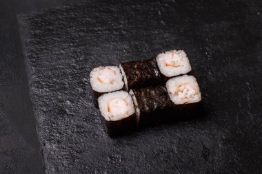 Siyah arka planda karidesli maki suşi rulolarının yakın çekimi