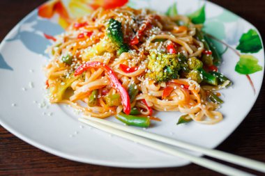 Seramik tabakta brokoli ile kalın buğday eriştesi. Japon yemeği..