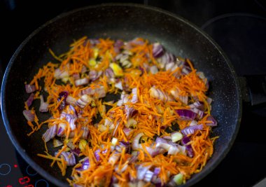 Tavada soğan ve havuç yakın planda..