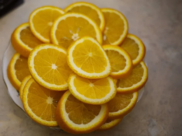 テーブルの上のプレート上のオレンジ 円でスライス — ストック写真