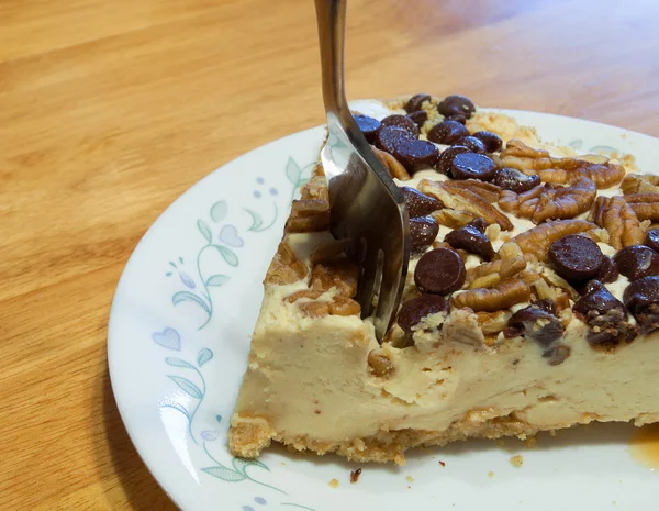 Fork going into Turtle cheesecake — Stock Photo, Image