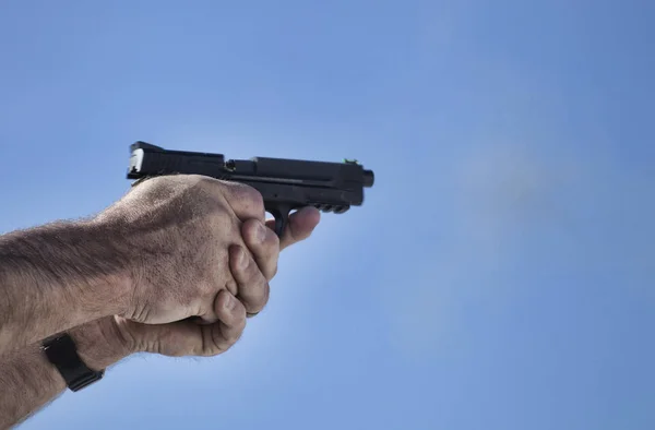 Пистолет в момент выстрела — стоковое фото