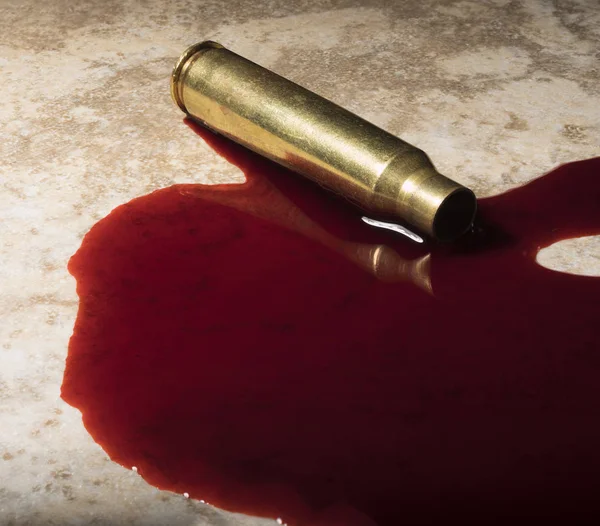 血のプールにライフルの黄銅 — ストック写真