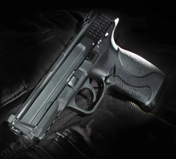 Pistola semiautomática sobre material negro — Foto de Stock