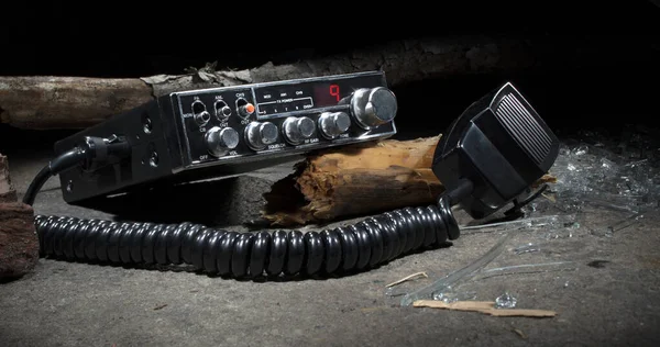 CB radio dialed to channel 9 with lots of broken wood and glass