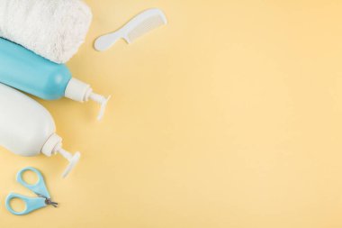 Bebeğim, yeni doğan çocuk bakım aksesuarları. Çocuk, sarı arka planda bebek sağlığı ürünleri var. çocuk bakımı kavramı