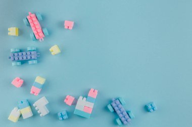 Renkli yapı blokları. Oyuncak tuğlalar düzen olmadan yalan söylüyor. Renkli oyuncakların arasında metin için yer. Metin için yer.