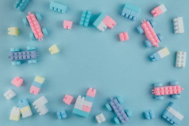 Renkli yapı blokları. Oyuncak tuğlalar düzen olmadan yalan söylüyor. Renkli oyuncakların arasında metin için yer. Metin için yer.